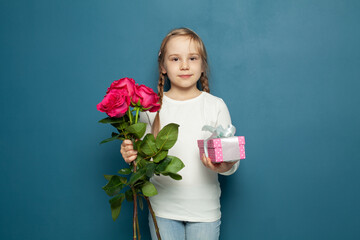 Little daughter child girl with pink flowers rose and gift box. 8 march card or Mothers day concept