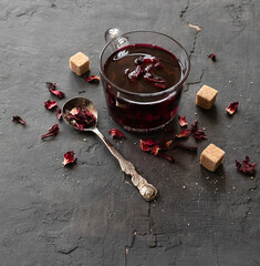 Red hibiscus tea in a glass mug on a black background. Top view © Rika777