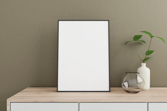 Minimalist and clean vertical black poster or photo frame mockup on the wooden table in living room with vase and plant