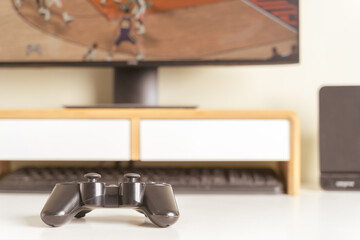 Close up of gaming controller to play console game or online computer game on white desk at home. Gaming is technology of sport as e sport for relaxing, make friend, teamwork. Gaming play concept.