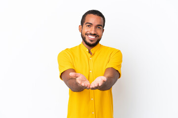 Young Ecuadorian man isolated on white background holding copyspace imaginary on the palm to insert...