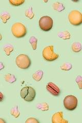 Fototapeta na wymiar Yummy artisans the patisserie concept. Many macarons, in mix with soft pop gummy sweets with different colors and taste. Flat lay green awesome background.