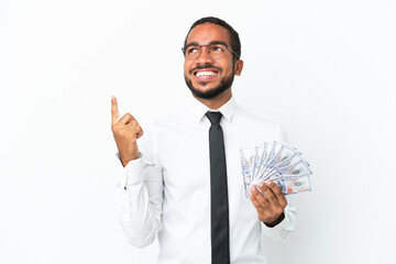 Young business latin man taking a lot of money isolated on white background pointing up a great idea