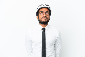 Young business latin man holding a bike helmet isolated on white background and looking up