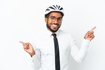 Young business latin man holding a bike helmet isolated on white background pointing finger to the laterals and happy