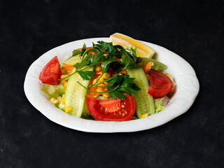 Fresh mixed salad with endive and cherry tomatoes on black plate dining, pouring olive oil