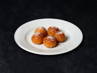 Turkish Traditional Dessert Kemalpasa, on a white plate on a dark background