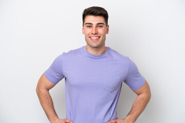 Young caucasian man isolated on white background posing with arms at hip and smiling