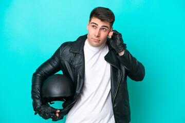 Naklejka premium Young caucasian man with a motorcycle helmet isolated on blue background frustrated and covering ears