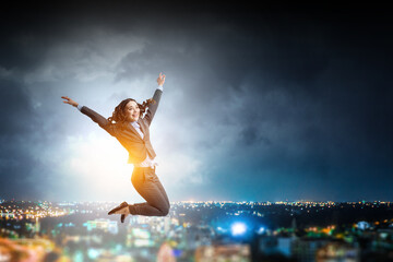Fototapeta na wymiar Portrait of energetic businesswoman jumping in open air