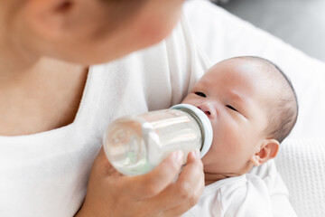 Obraz na płótnie Canvas Mother breast feeding milk to Asian newborn baby on white bed