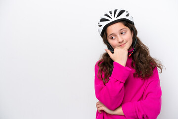 Little cyclist girl isolated on white background pointing to the side to present a product