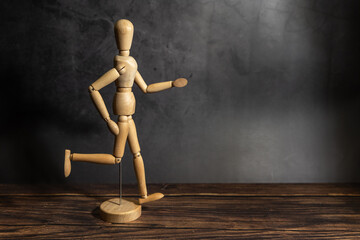 wooden mannequin wtih walking pose, dark background