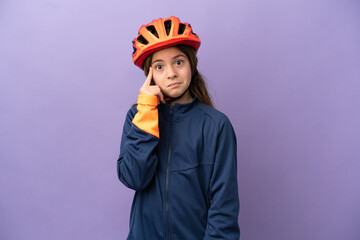 Little caucasian girl isolated on purple background thinking an idea