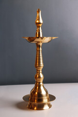 Indian traditional samai or samayee diya or deepam brass lamp on gray white background