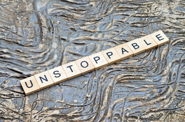 unstoppable text on wooden square, motivation and business quotes