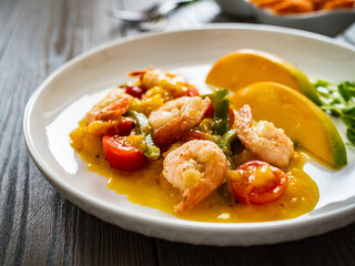 Prawns in mango sauce on wooden table

