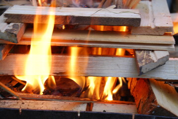 A fire is lit on the wood prepared for him. Several pine and birch logs are stacked in a square tower in the center of which sawdust and wood chips begin to flare up.