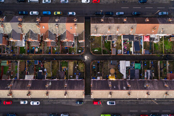 Aerial bird's eye view of the rooftops of terraced houses and back yards in a Northern UK city