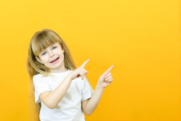 Wow, look, advertise here! Portrait of an amazed cute girl pointing at an empty space in the background, a preschool girl