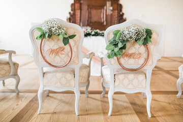 Wedding ceremony setup chairs with mr and mrs sign, decorated with white flowers, luxury indoor venue with natural light