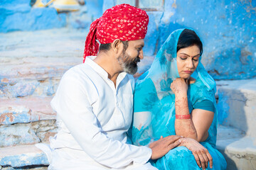 Traditional indian couple sitting together having relationship difficulties. husband to make up...