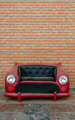 A red car sofa with black faux upholstery, on isolated background with clipping path.