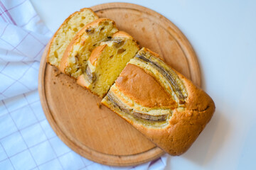 Homemade banana bread pie on a wooden plate. Sweet organic plant based traditional bakery. Top view. Cozy morning. Small business and artisanal. Super market and cafe template, whole grain flour.