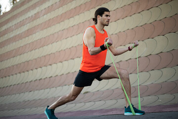 Young muscle man training outside. Fit handsome man doing exercise.