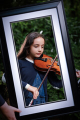 Young girl playing the viola in nature