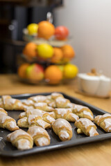 Fresh croissants with frosting on a baking tray