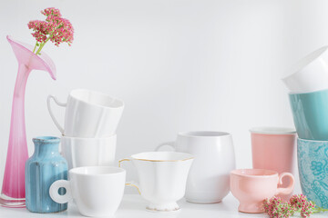 Clean dishes and flowers on wooden shelf