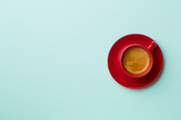 Cup of delicious coffee on color background, top view