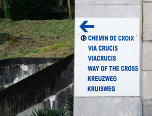 Lourdes, France - February 1, 2022: Sign indicating in different languages the direction of the Way of the cross (engl.Translation)