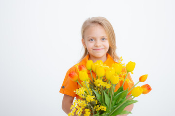 cute little blonde girl in a dress holding a bouquet of spring flowers on a white background. A child holds a bouquet of yellow tulips isolated on a white background.