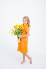 cute little blonde girl in a dress holding a bouquet of spring flowers on a white background. A child holds a bouquet of yellow tulips isolated on a white background.