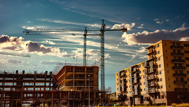 Construct with building crane.Sunset landscape and construction cranes and buildings.