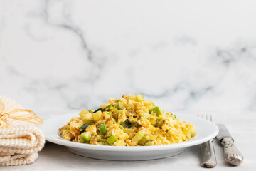scrambled egg with zucchini on white small plate