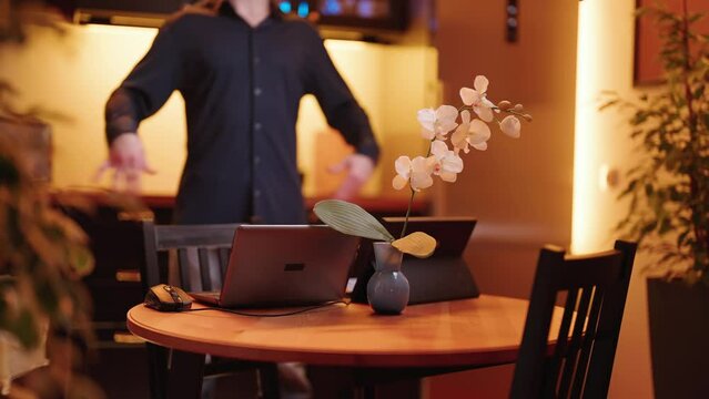 Businessman in kitchen with laptop computer doing flexibility exercises 4K
