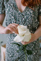 Florist holds a white rose in his hand for a bouquet