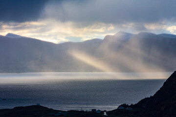 Sunbeams from at dark clouds in a beautiful fjord