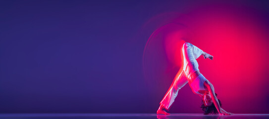 Young sportive beautiful girl, hip-hop dancer dancing hip hop isolated on purple background in pink neon light. Youth culture, style and fashion, action. Flyer