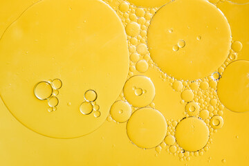 Fototapeta Golden yellow abstract oil bubbles or face serum background. Oil and water bubbles macro photography. obraz