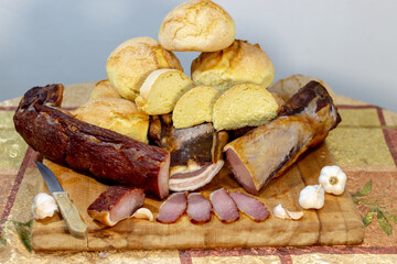 Close-up of organic food. Smoked meat on the table with garlic and homemade bread, smoked bacon on a wooden board.