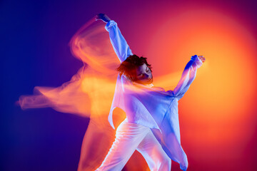 Image of flexible young girl, hip-hop dancer in white outfit dancing hip hop isolated on blue...