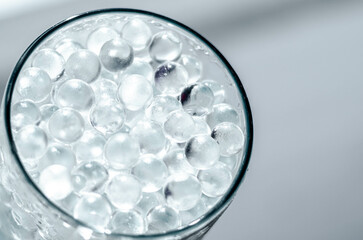 Hydrogel balls in a glass vase. Hydrogel as an art object or background for a computer desktop. Hydrogel close-up.