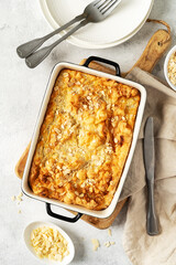 Pudding or oatmeal pie in a baking dish on a light gray culinary background. Casserole of cereals with nuts on the kitchen table top view with copyspace. Healthy and nutritious breakfast