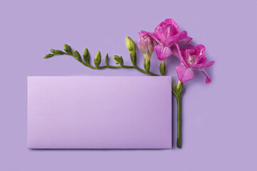 Greeting card with envelope and freesia flower on very peri background
