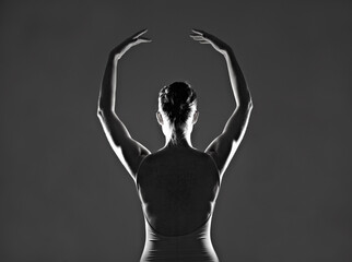 She lives to dance. Silhouette of a young ballerina dancing against a dark background.