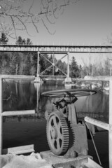Obraz premium Dam gear and railway bridge over river in winter in Quebec, Canada